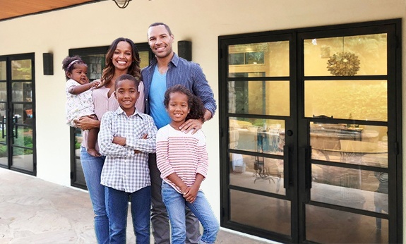 Family of five in front of home with custom iron doors
