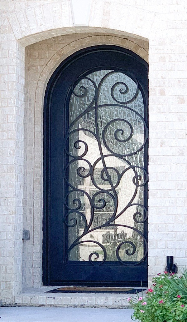 Iron single door with round top and intricate design