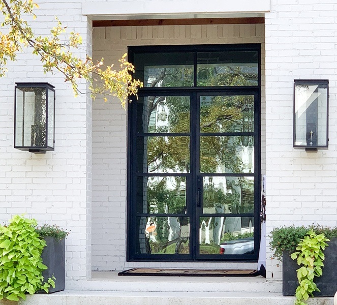 Large double front door with square top made of rectangles of glass and iron