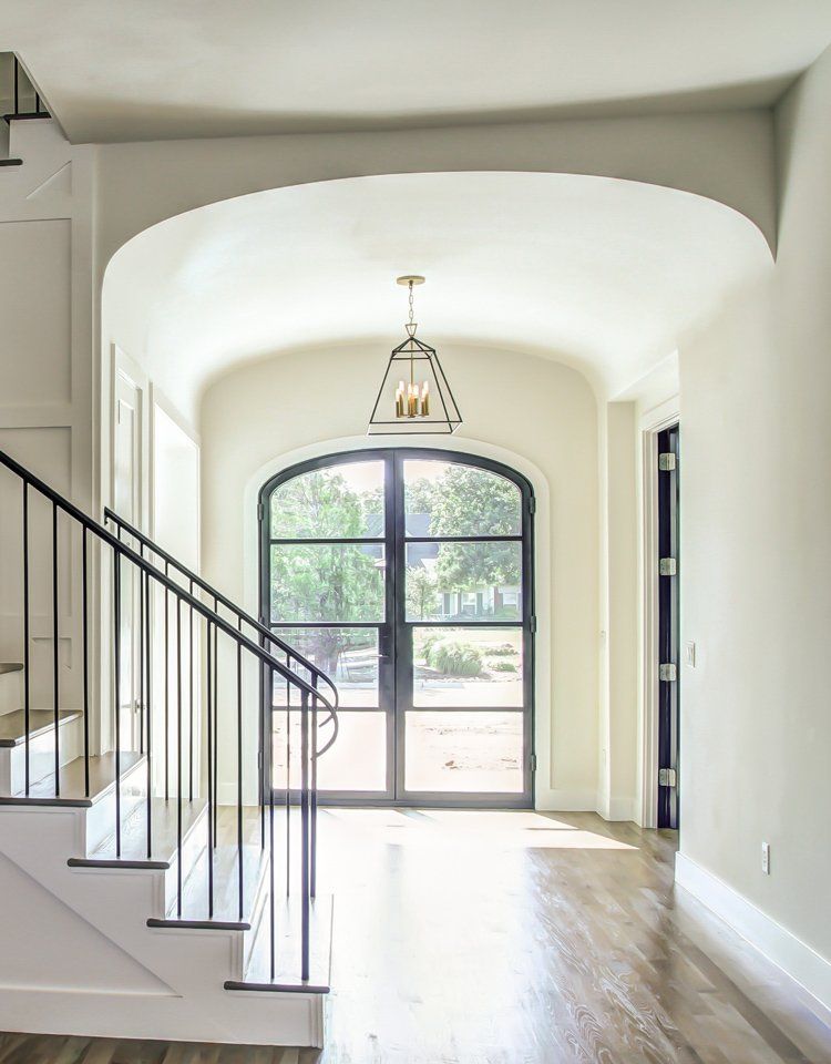 Front entry with iron work stair railing and large iron double doors