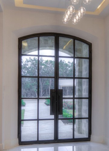 Eyebrow top iron double  doors with a grid work of metal over glass