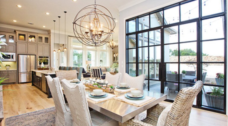 Large windows and iron double doors leading from dining room onto the patio