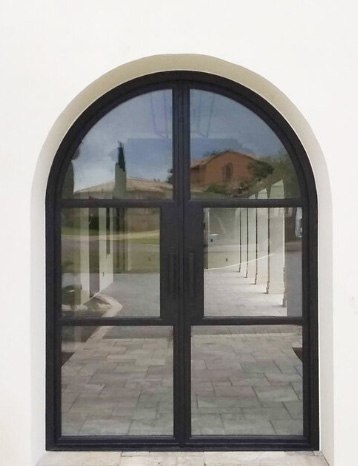 Large round top double doors with black finish encasing windows