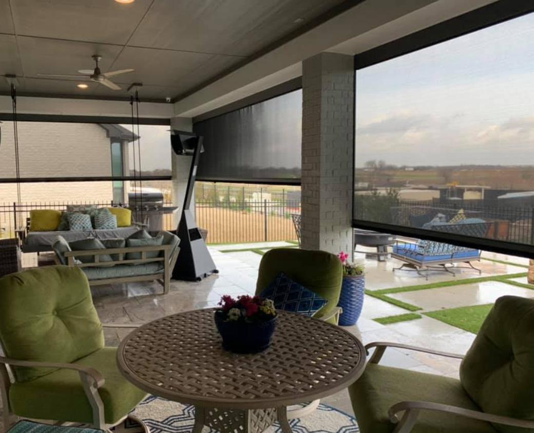 Enclosed porch opening to patio with motorized shades