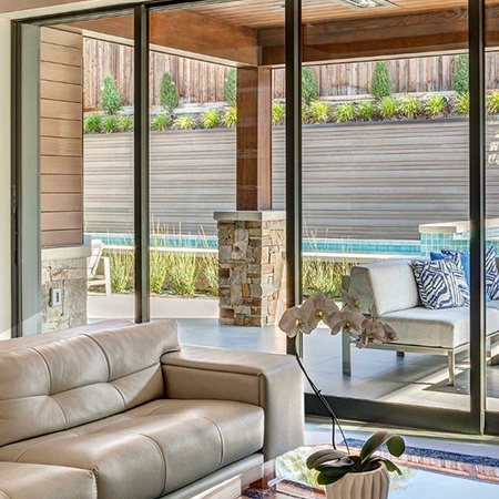 Home with custom sliding glass wall opening onto porch