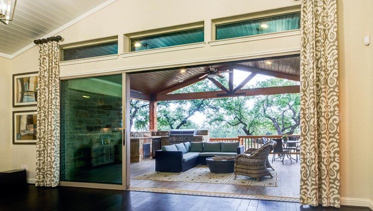 Looking out onto patio from living area through open sliding glass wall