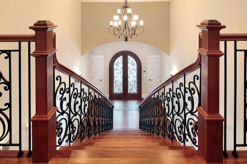 a view of a home with wrought iron doors and a staircase